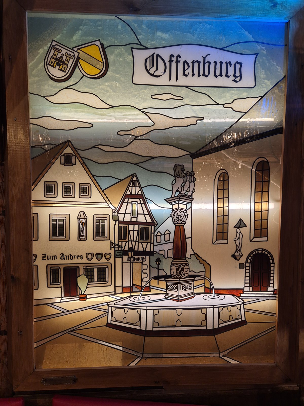 Beleuchtetes Glasbild mit Offenburger Stadtmotiven, dem historischen Brunnen und dem Restaurant Zum Andres